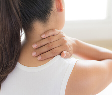 Woman rubbing back of her neck