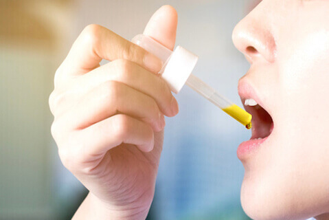 Woman using allergy drops