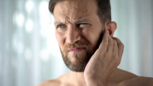 man holding his face