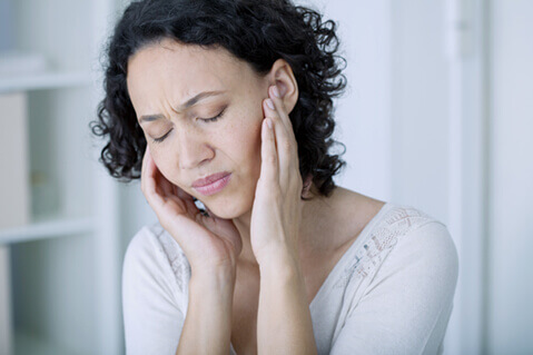 Woman with tinnitus holding hears